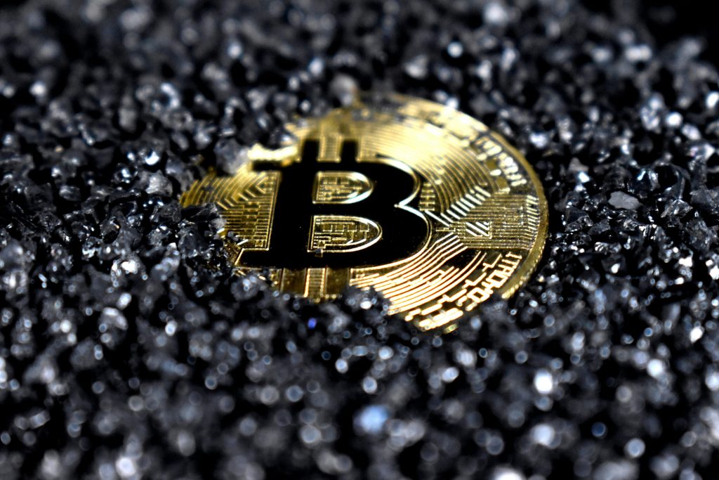 Bitcoin coin on a dark textured surface