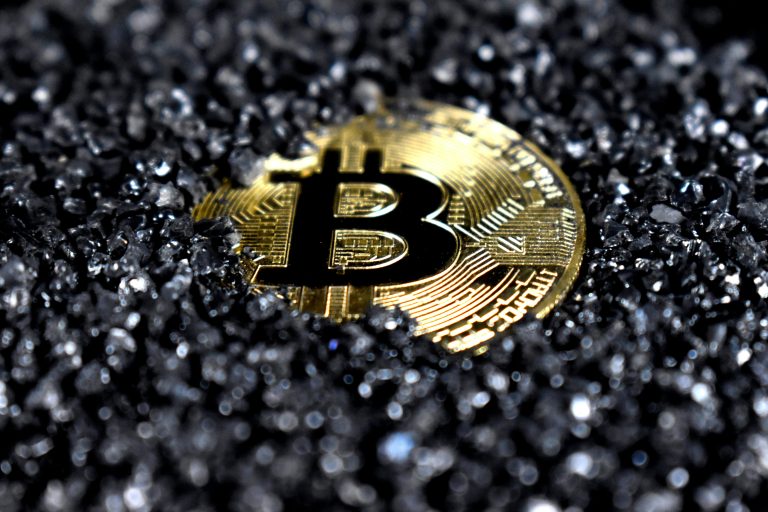 Bitcoin coin on a dark textured surface