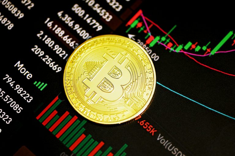 Bitcoin coin over a cryptocurrency candlestick chart