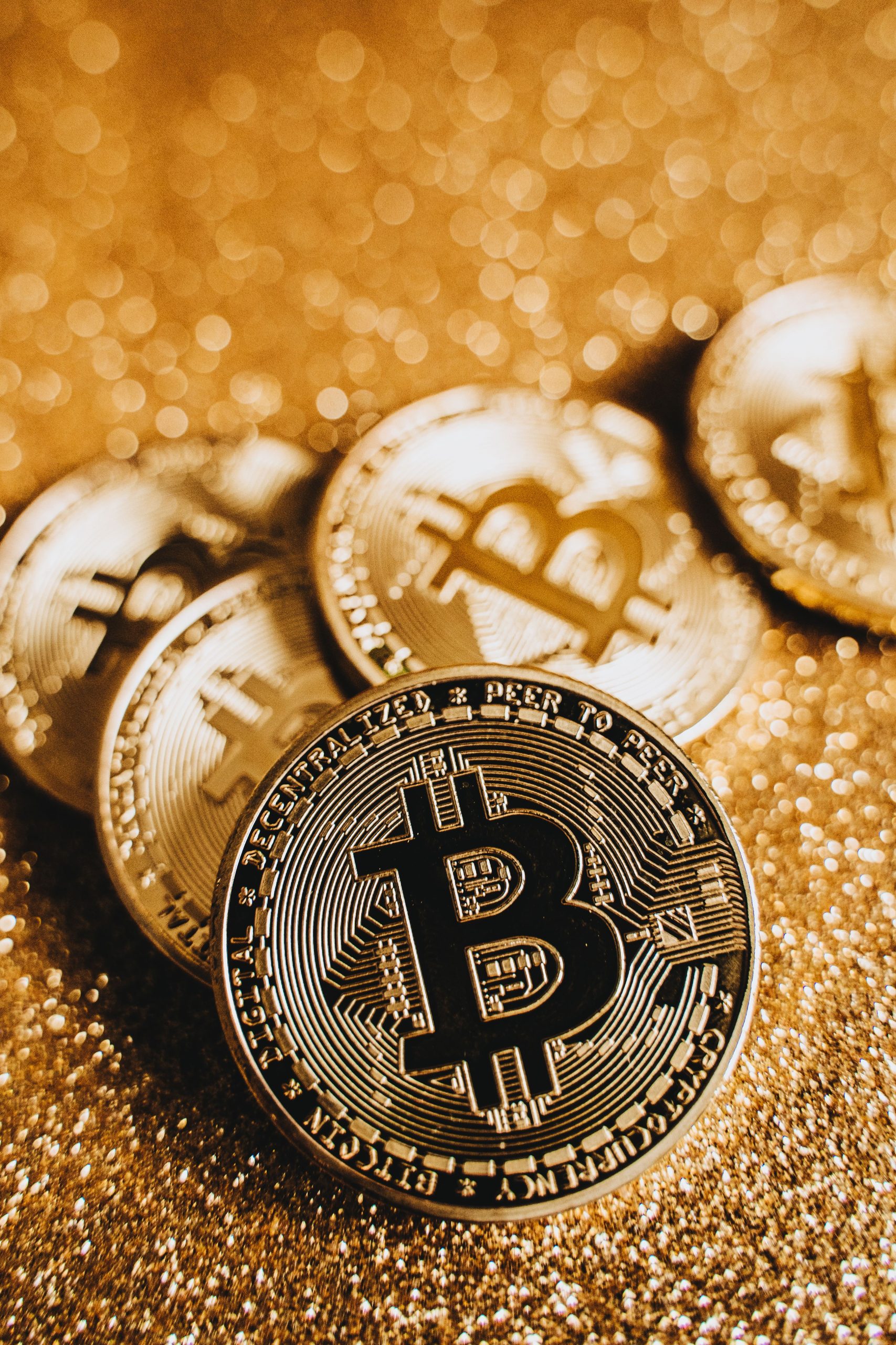 Bitcoin coins on a gold surface representing the Bitcoin-gold correlation trade