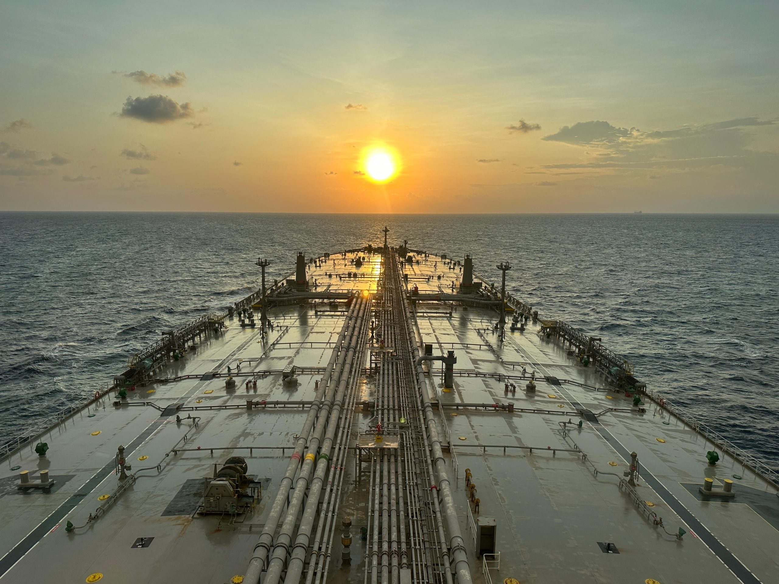 Oil tanker at sea during sunset representing Strait of Hormuz energy risk