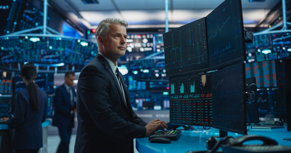 Financial analyst at a multi-monitor market workstation