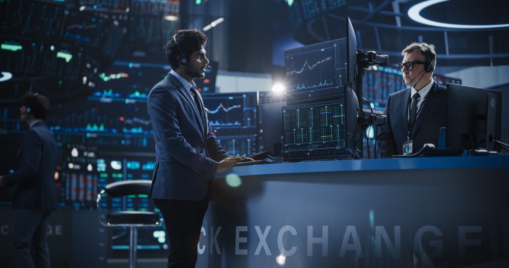 Financial trader at a multi-monitor market workstation for foreign-exchange coverage