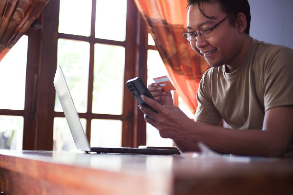 Person using smartphone credit card and laptop for an online payment