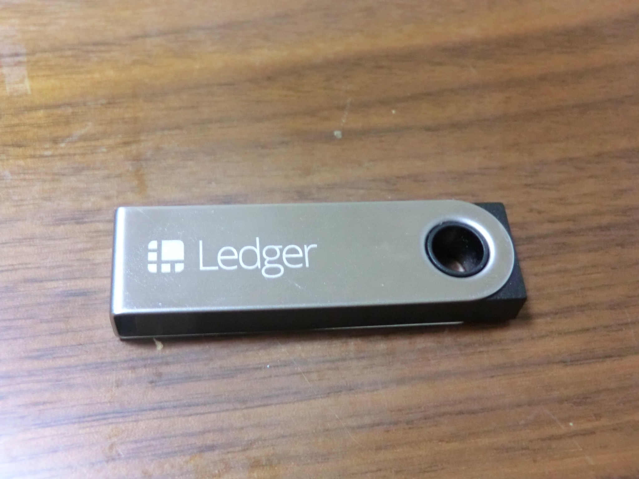 Ledger Nano S hardware wallet on a wooden surface