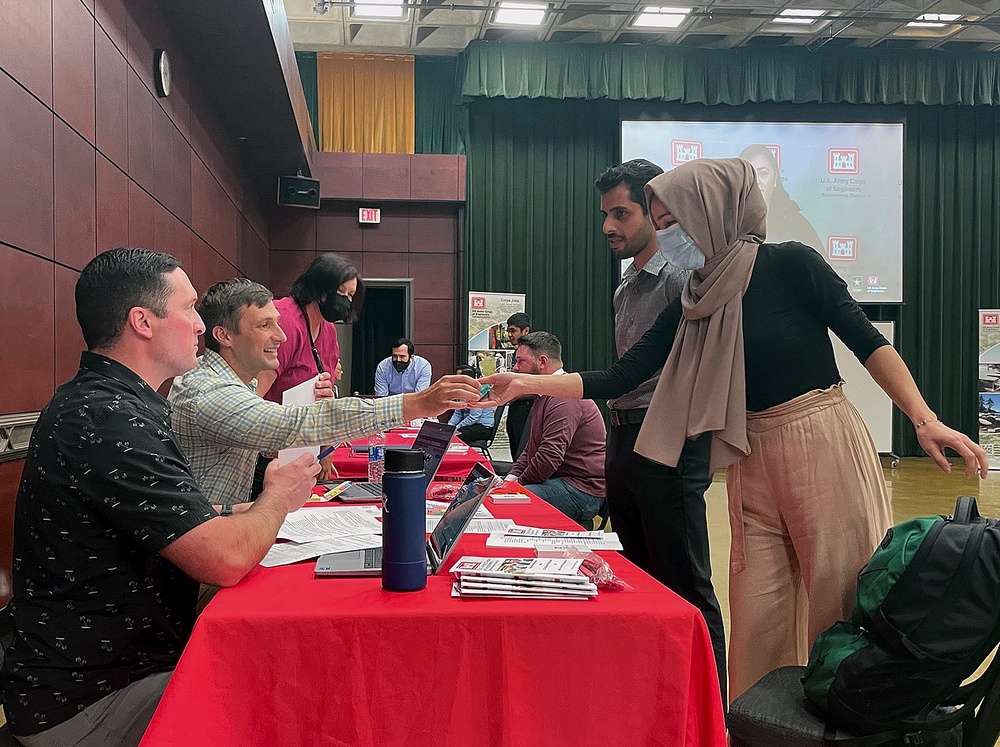 Jobseekers speak with recruiters at a university job fair, illustrating the September 2026 U.S. employment report